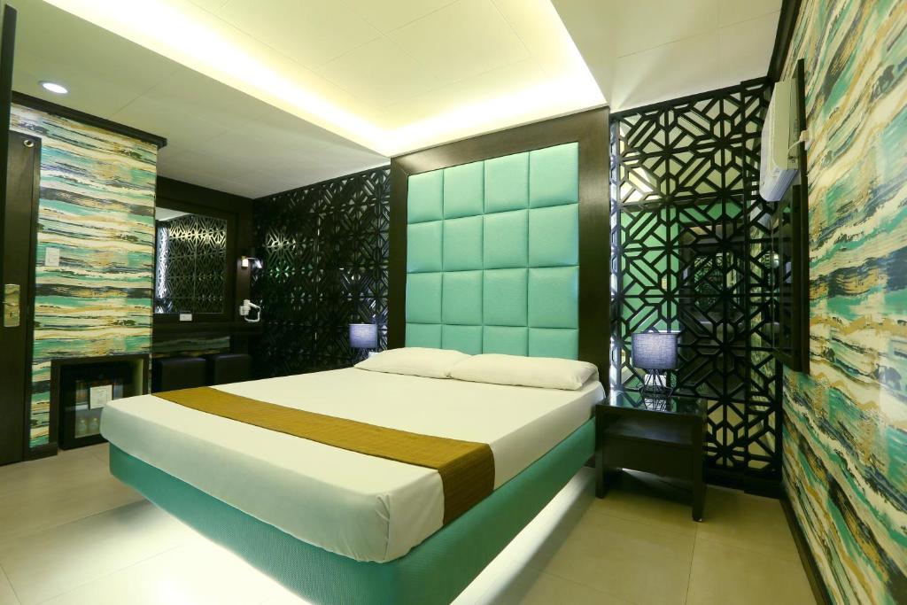 a bedroom with a large bed in a room at Hotel Ava Malate in Manila