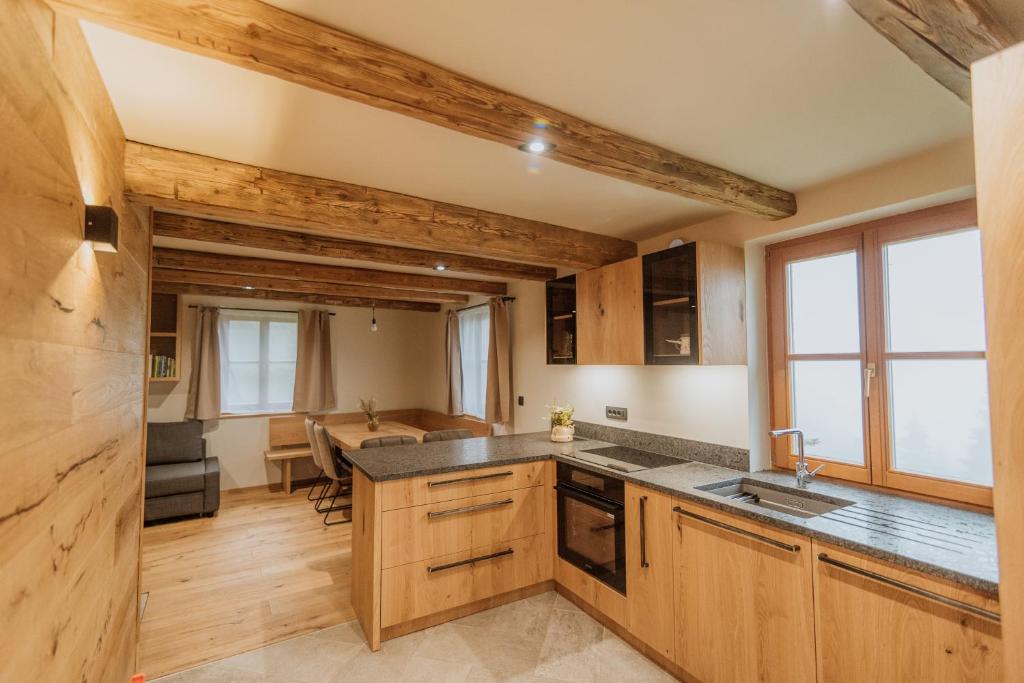 eine Küche mit Holzschränken und ein Esszimmer in der Unterkunft Cottage Planska koča in Vitanje