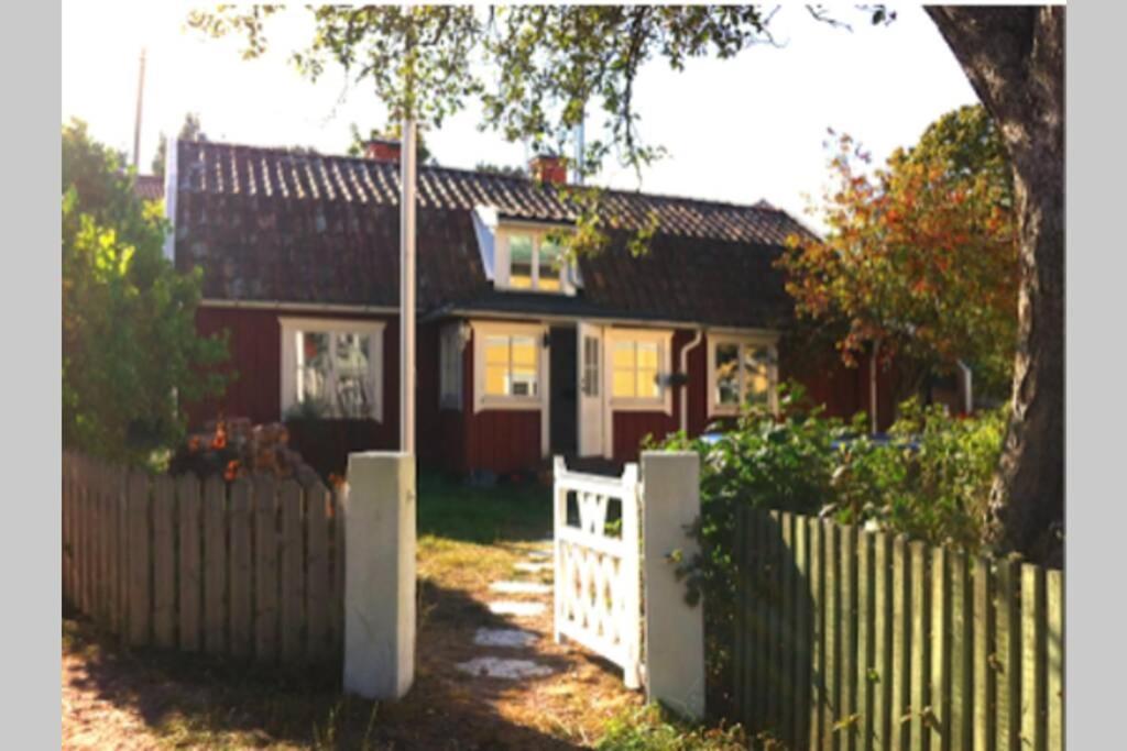 dom z białym płotem przed nim w obiekcie House for 7-8 central in Sandhamn, access to dock w mieście Sandhamn