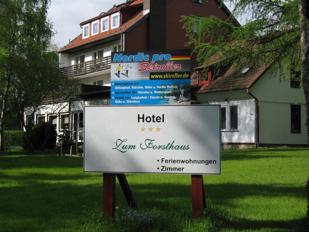 a sign in the grass in front of a house at Bio-Hotel Zum Forsthaus in Altenau
