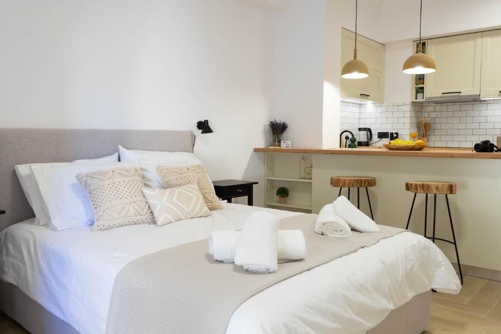 Marilias Luxury Studio Apartment في كيساموس: غرفة نوم بسرير ابيض عليها مناشف