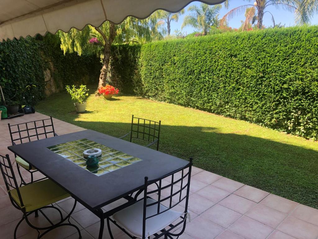une table et des chaises assises sur une terrasse dans l'établissement PARC DE DIANE, à Antibes