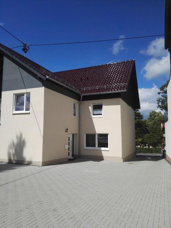 a large white house with a brick driveway at Ferienwohnungen Ilona Blick in Kelberg