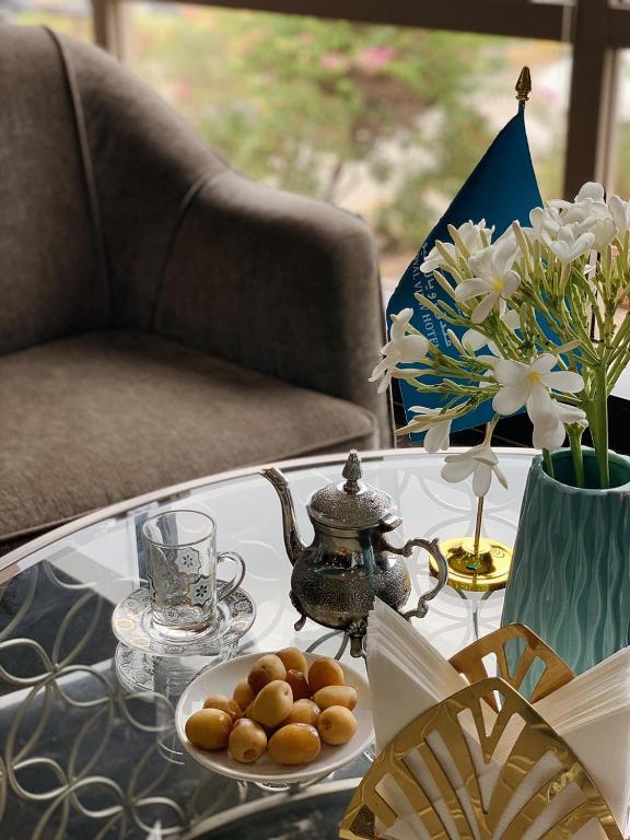 a coffee table with a tea pot and a plate of food on it at Royal View Hotel in Ras al Khaimah