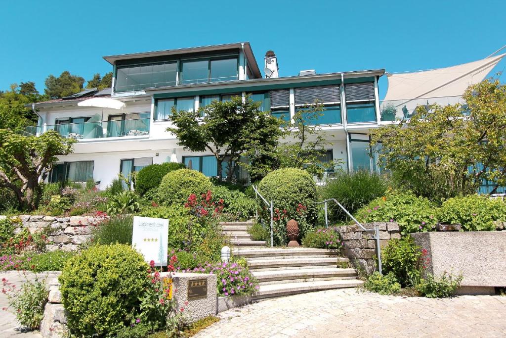 a house with a staircase in front of a garden at Lupinenhotel Bodensee - Apartment mit Seeblick in Sipplingen