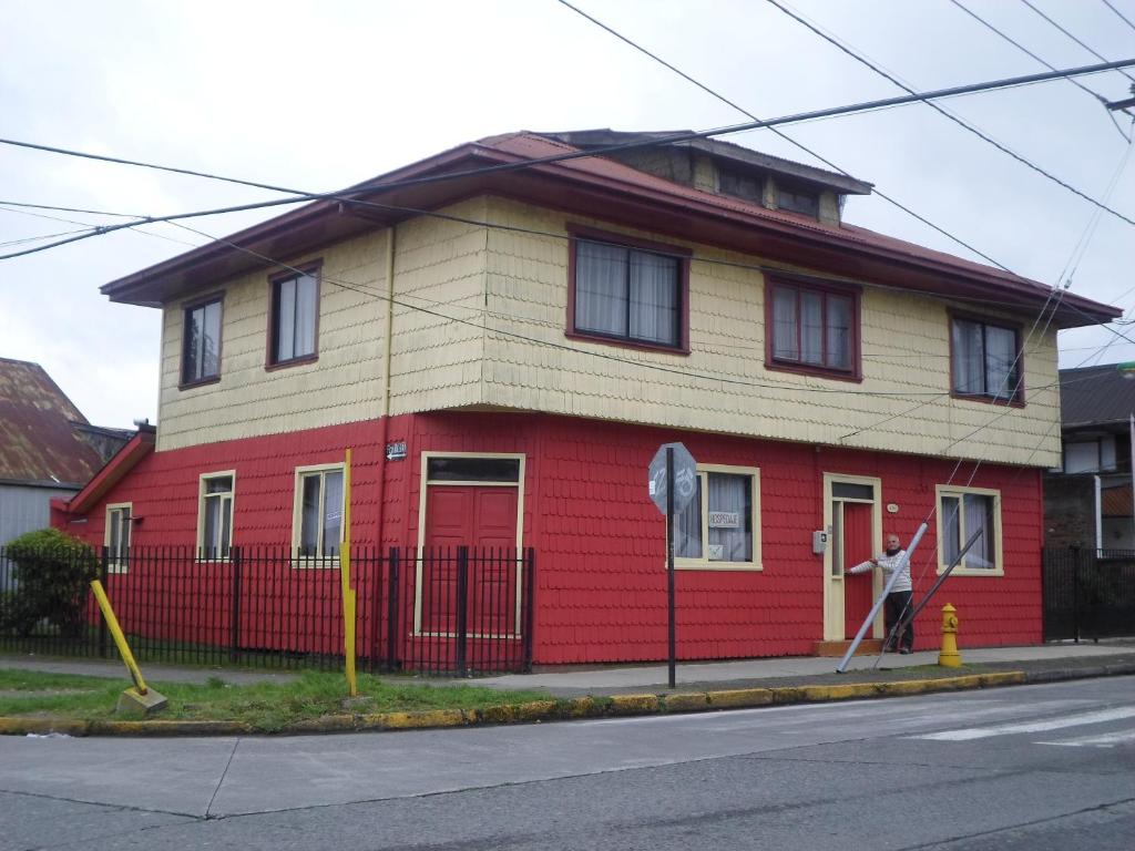 a red and yellow house on the corner of a street at Hospedaje Teresita in Puerto Montt