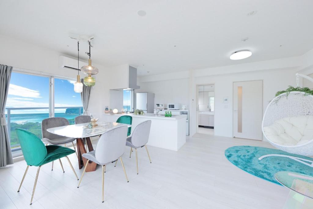 a white kitchen and dining room with a table and chairs at クリスタルエグゼ南紀白浜2 in Shirahama