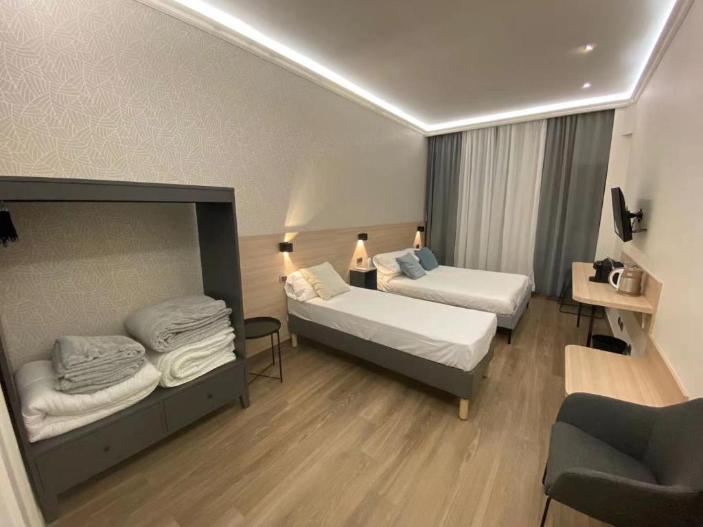 pokój hotelowy z 2 łóżkami i kanapą w obiekcie My Maison 70 w Rzymie