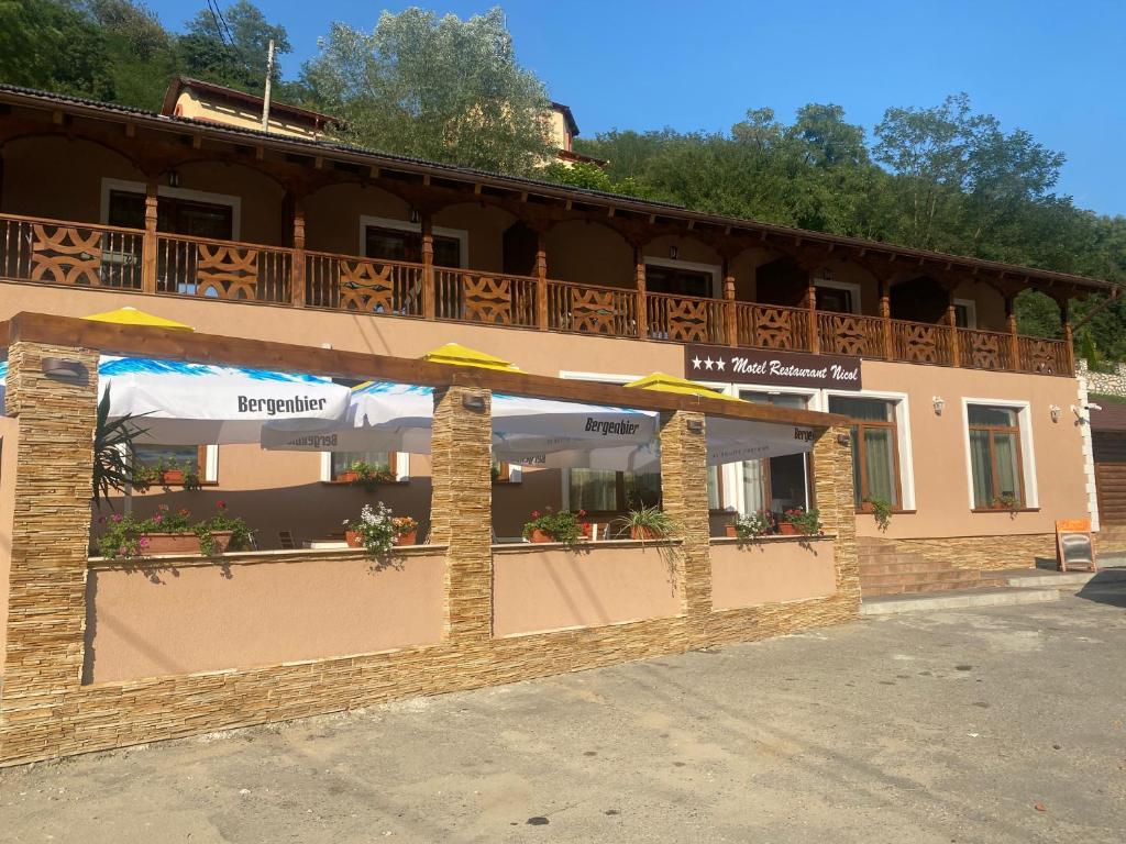un edificio con un balcón en el lateral. en MOTEL Restaurant NICOL ARMENIS en Armeniş