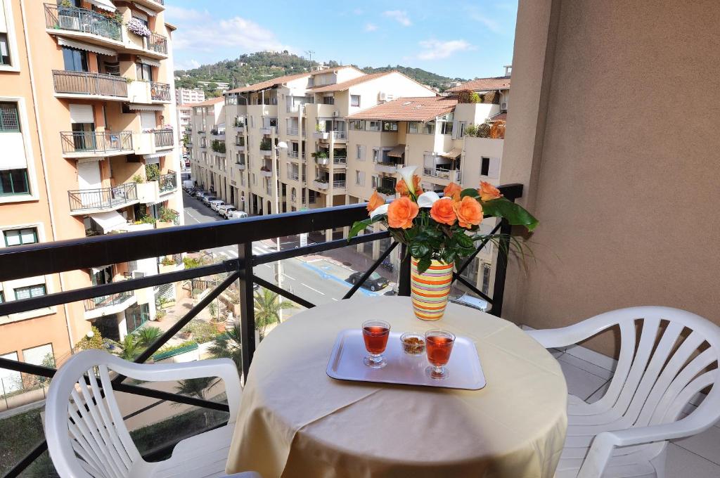 - une table avec un vase de fleurs sur le balcon dans l'établissement Residhotel Villa Maupassant, à Cannes