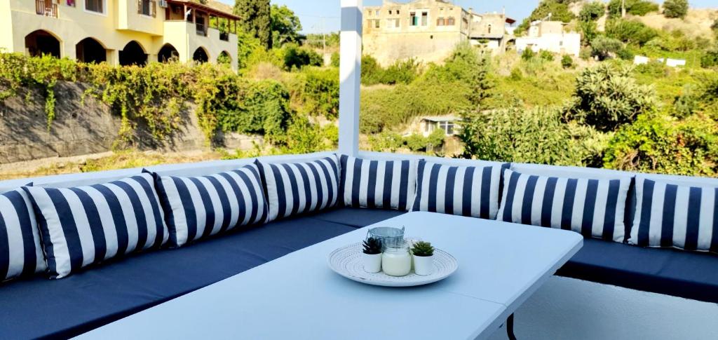 ARGi House في Maroulás: طاولة بيضاء مع طبق من الطعام على الأريكة
