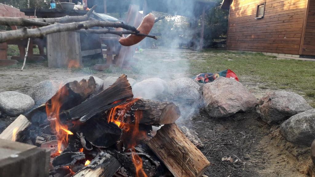 a campfire with a hot dog on top of it at Hacjenda Leśny Zaułek in Włodawa