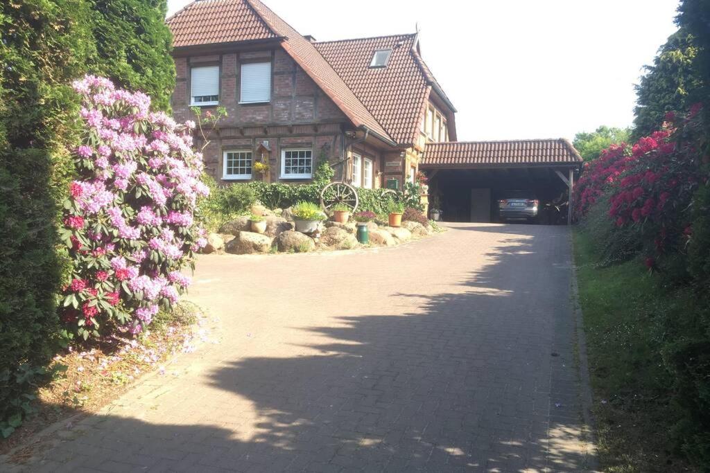 a house with a driveway and flowers in front of it at Ferienwohnung Schmidt in Rosengarten