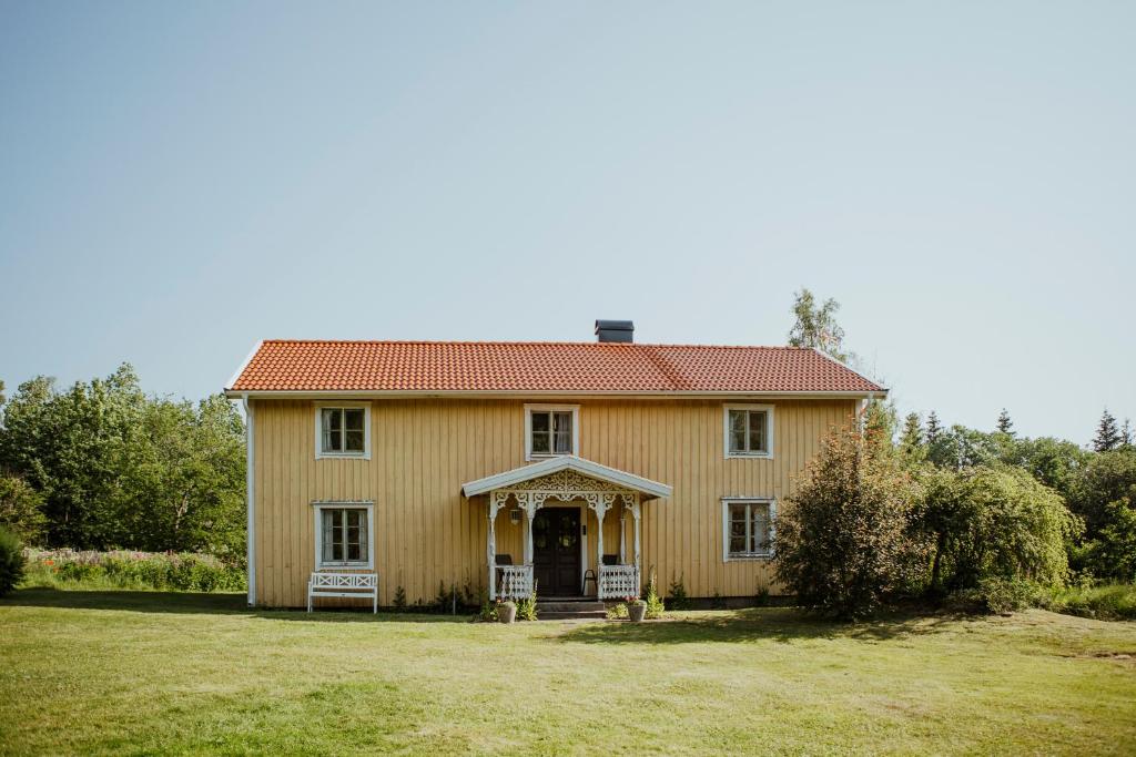uma casa velha com um telhado vermelho num campo em Kylås Vildmark em Skillingaryd
