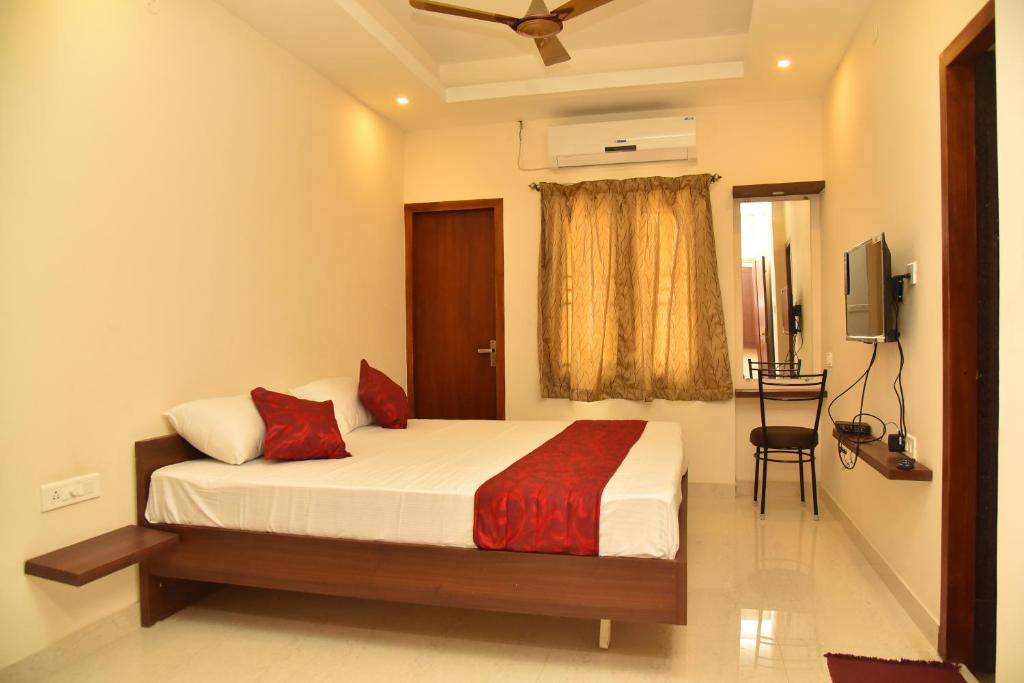een slaapkamer met een bed en een televisie. bij Home Stay @ Kommiya Inn in Kumbakonam