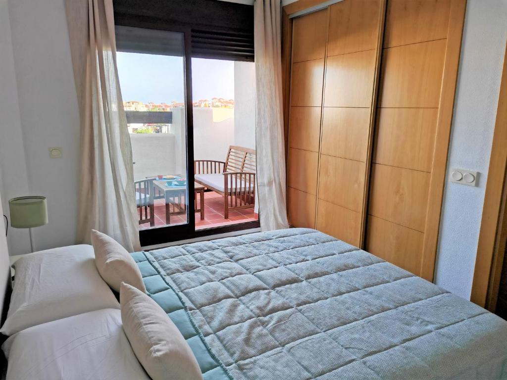 um quarto com uma cama e vista para uma varanda em VeraTespera - Apartamento en Vera Playa - Mascotas em Vera