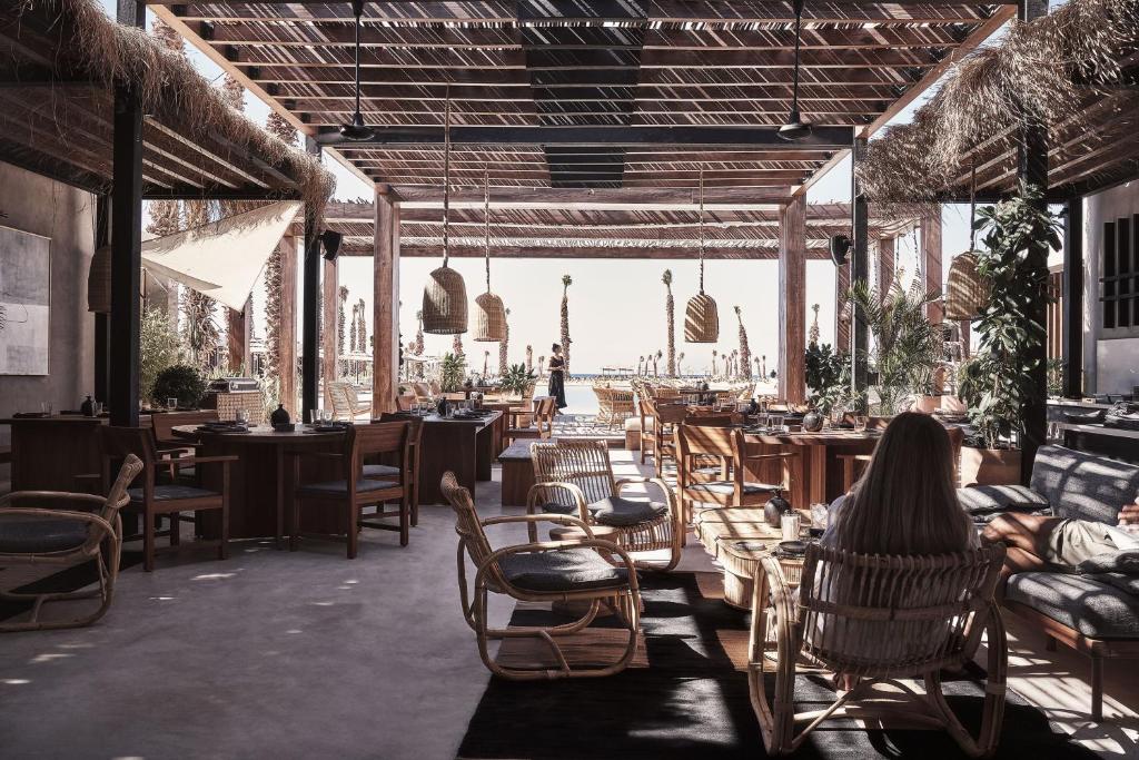 a woman sitting in a chair in a restaurant at Casa Cook North Coast - Adults Only in El Alamein