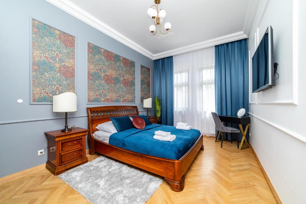 a bedroom with a bed with blue sheets and blue curtains at Trzy Gracje - Monte Cassino by OneApartments in Sopot