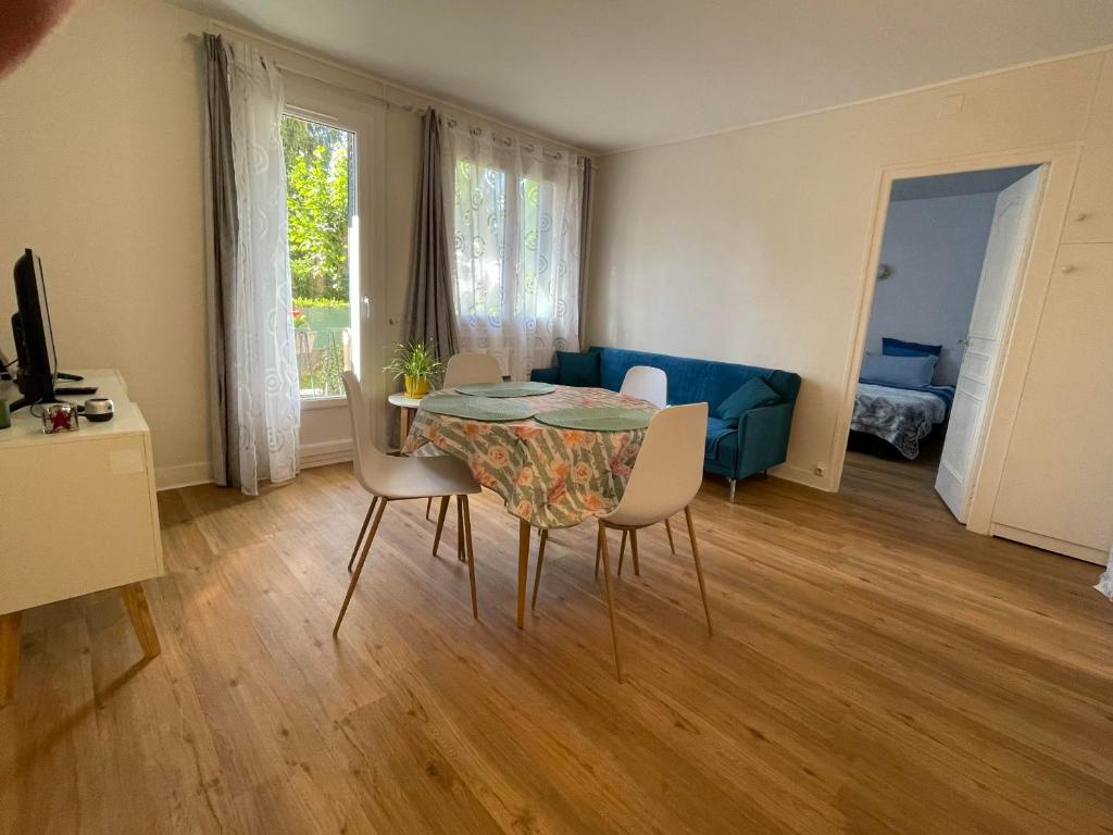 salon ze stołem, krzesłami i kanapą w obiekcie Turgot bleu w mieście Thonon-les-Bains