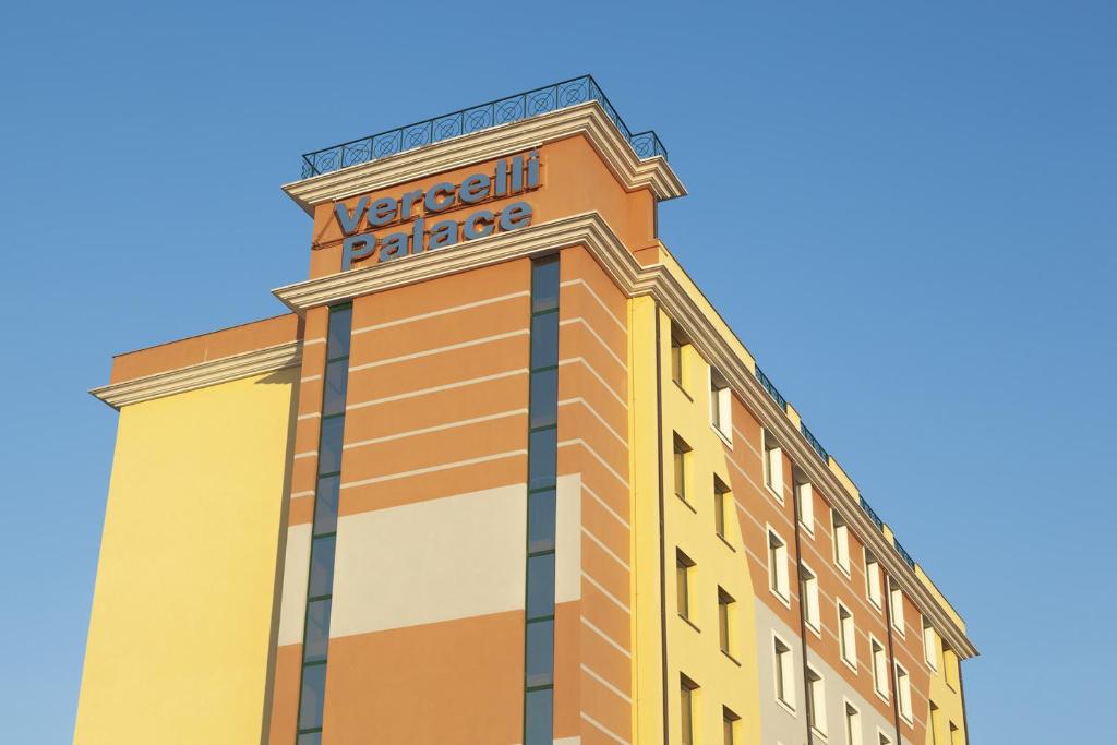 Un bâtiment avec un panneau en haut dans l'établissement Vercelli Palace Hotel, à Verceil