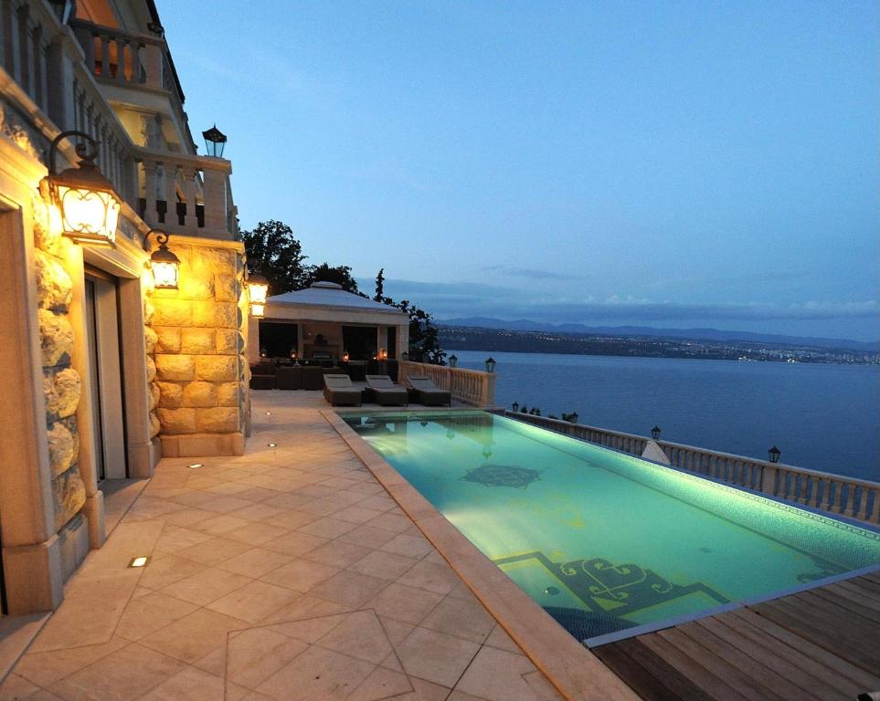 a swimming pool on a building with a view of the water at Villa Isabella - Luxury with style right next to the beach, private pool and sea view in Opatija