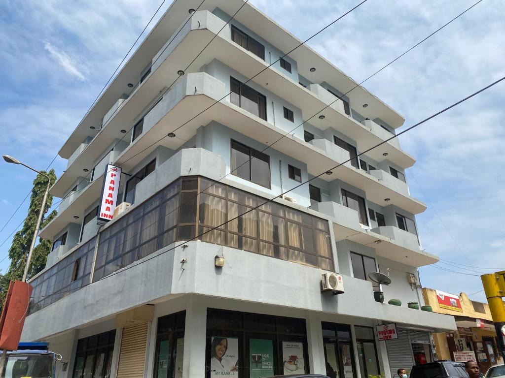 a tall white building on the corner of a street at Panama Inn Moshi in Moshi