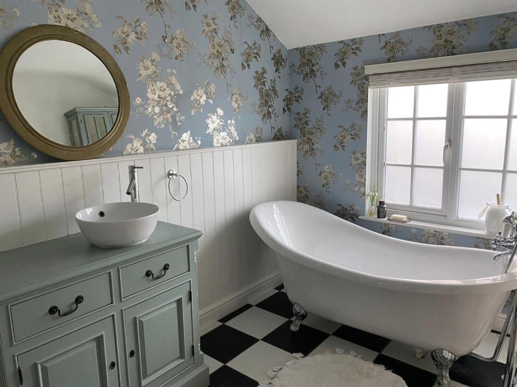 a bathroom with a tub and a sink and a mirror at Beautiful Apartment Wendens Ambo Saffron Walden in Wendens Ambo