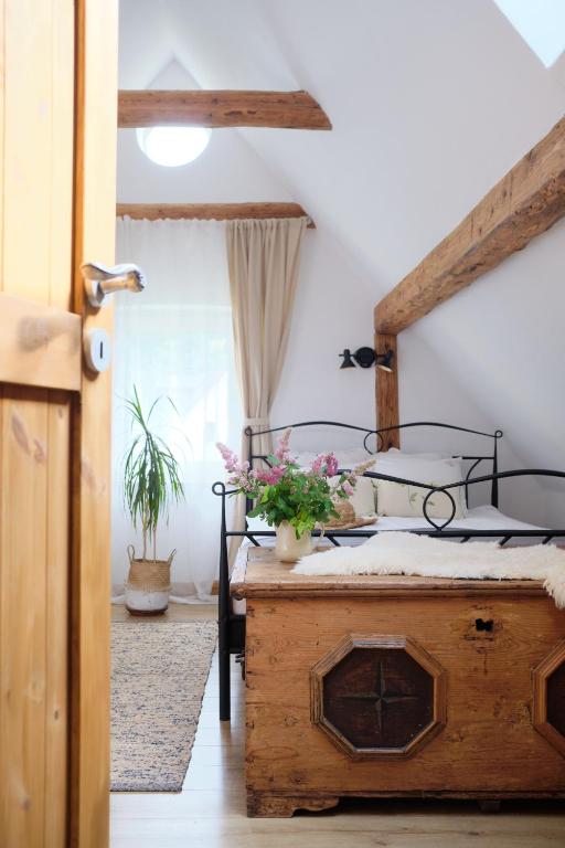 a bedroom with a bed and a table with flowers on it at Czereśniowy Dom in Jarkowice