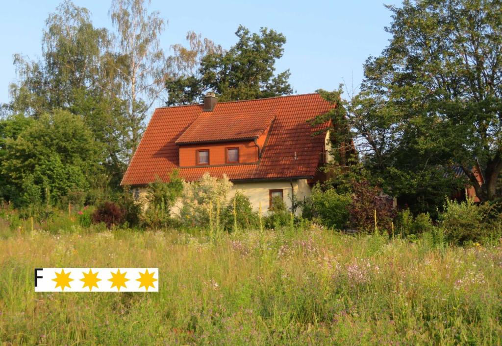 a house in a field with a sign in front of it at Ferienhaus Waldblick in Hohenberg an der Eger