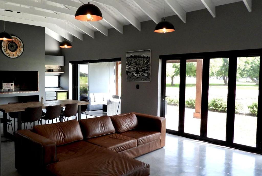a living room with a brown leather couch and a table at Comfort in Langebaan in Langebaan