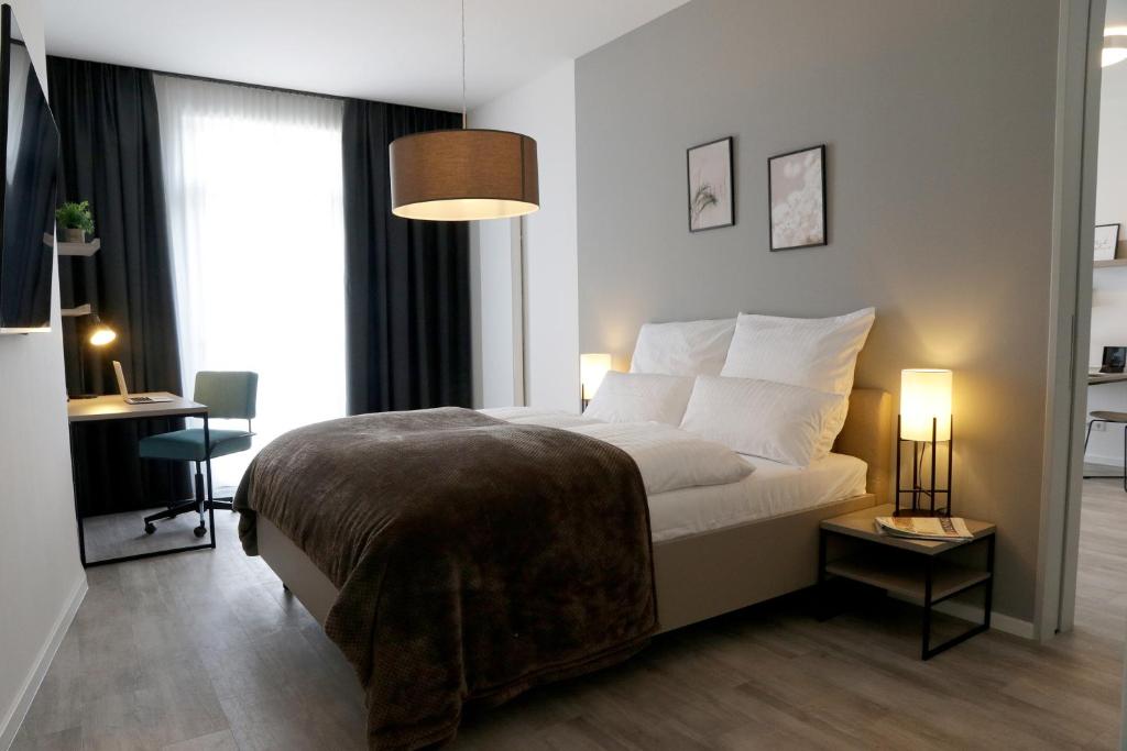Un dormitorio con una cama y un escritorio y una ventana. en PM-AM Apartments GmbH, en Dortmund
