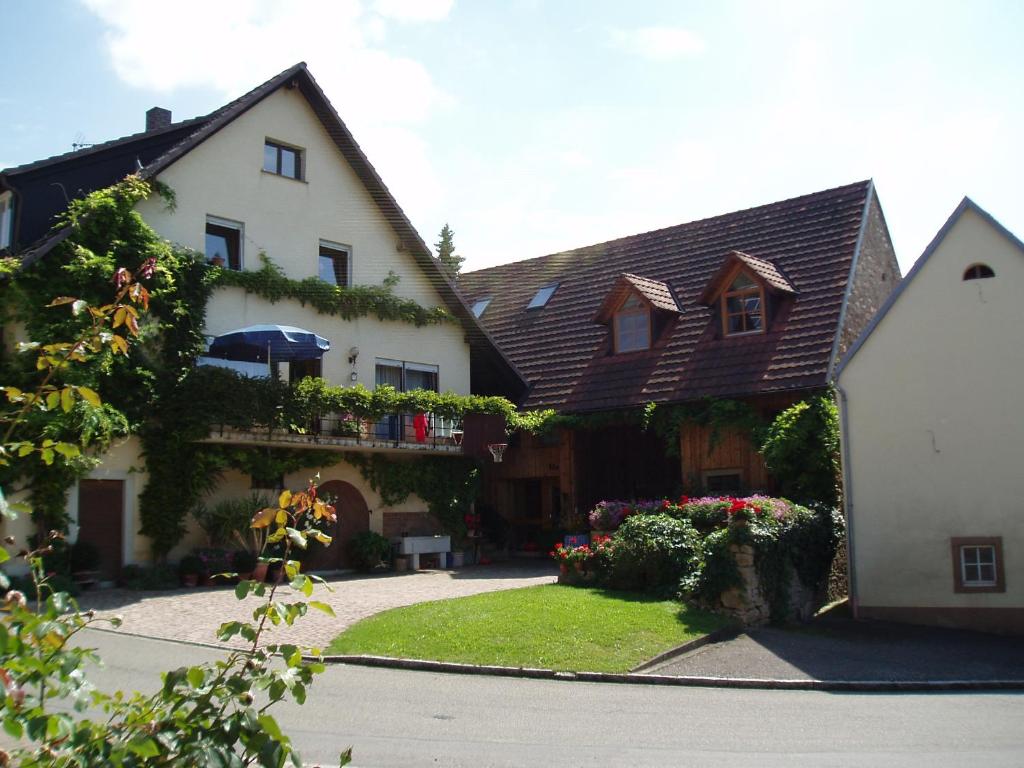 a large white house with a yard with flowers at Apartment Weinbergglück in Ebringen