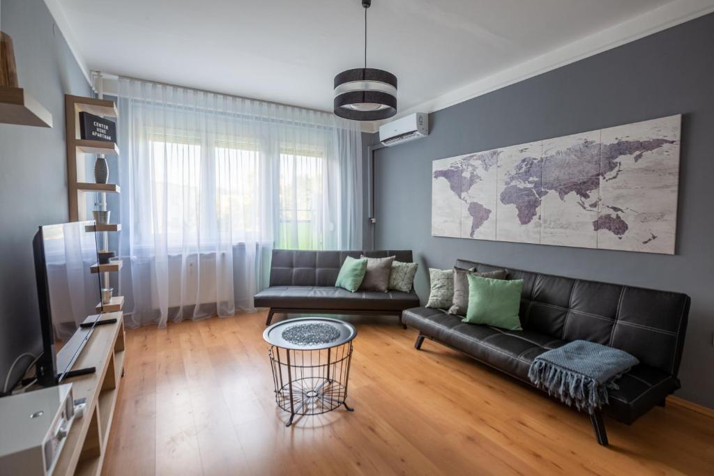 ein Wohnzimmer mit einem Sofa und einem Tisch in der Unterkunft Center Home Apartman in Orosháza