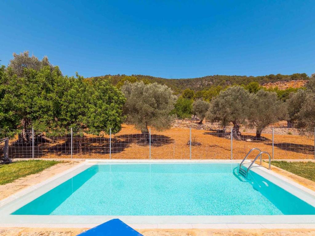 an empty swimming pool with trees in the background at Can Pasos in El Port de la Selva