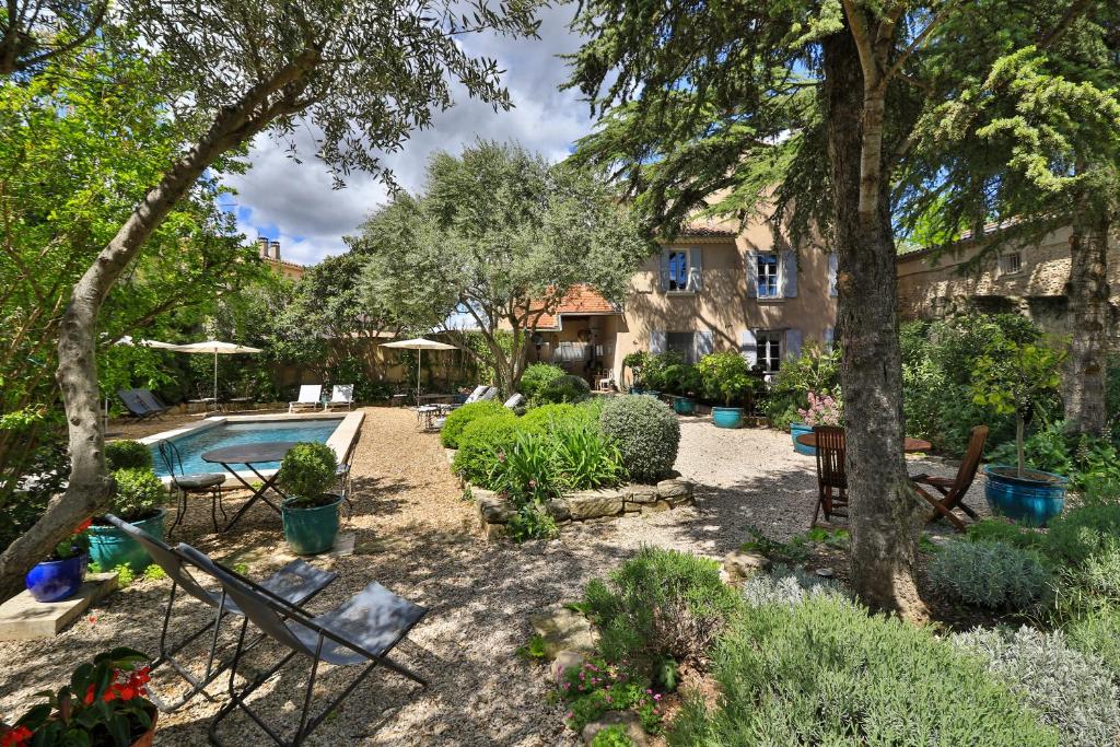 un cortile con piscina e alberi e una casa di Le Jardin de Mazan a Mazan