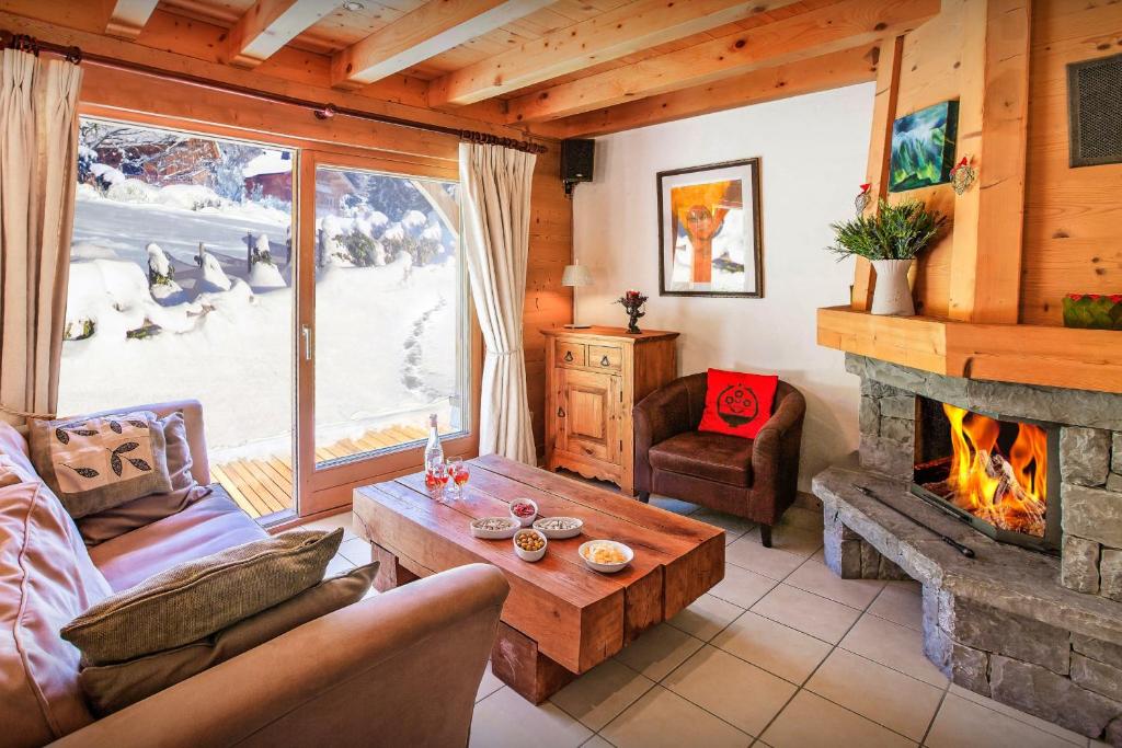 a living room with a fireplace in a cabin at Chalet L'Ours Blanc - OVO Network in Le Grand-Bornand