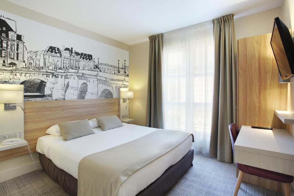 een hotelkamer met een groot bed en een bureau bij Lautrec Opera in Parijs