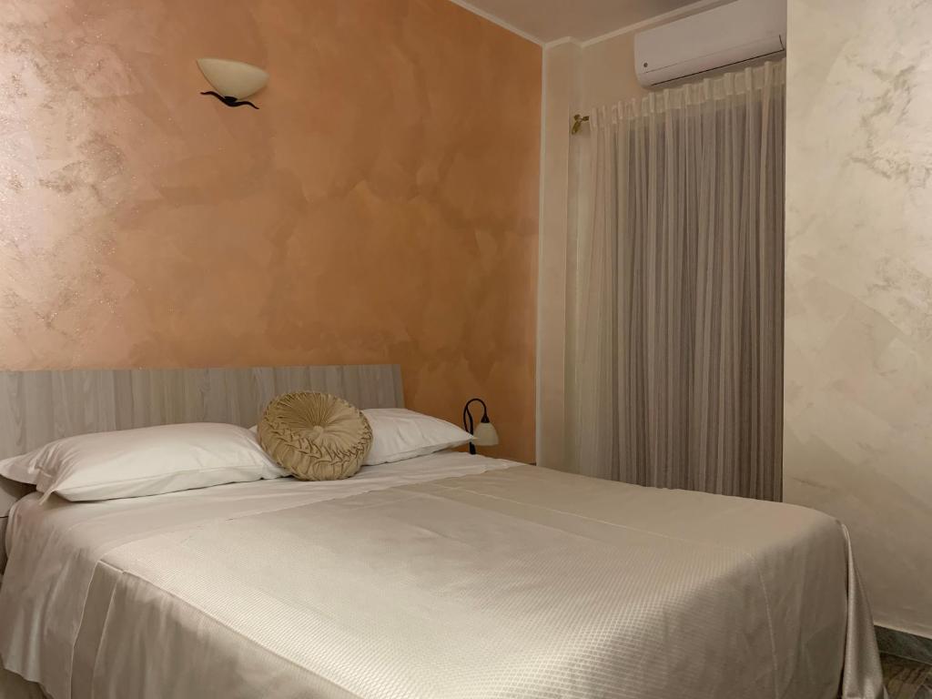 a bedroom with a white bed with a fan on it at Le Stanze della Braceria Calabrese in Scilla
