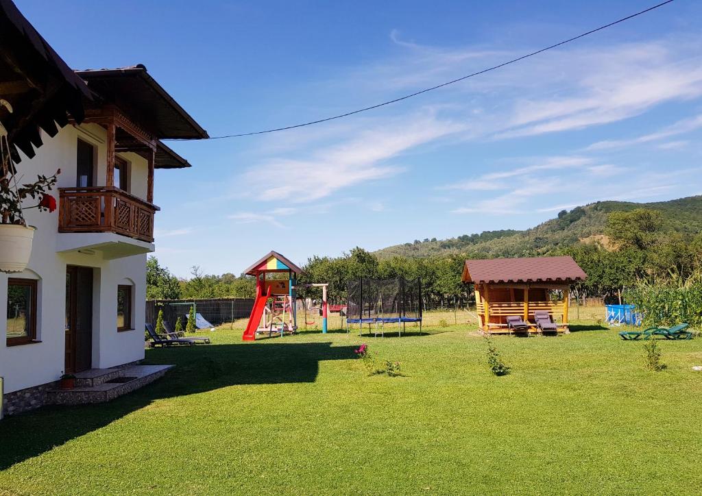 une cour avec une aire de jeux et une maison dans l'établissement La Bunicu, à Polovragi