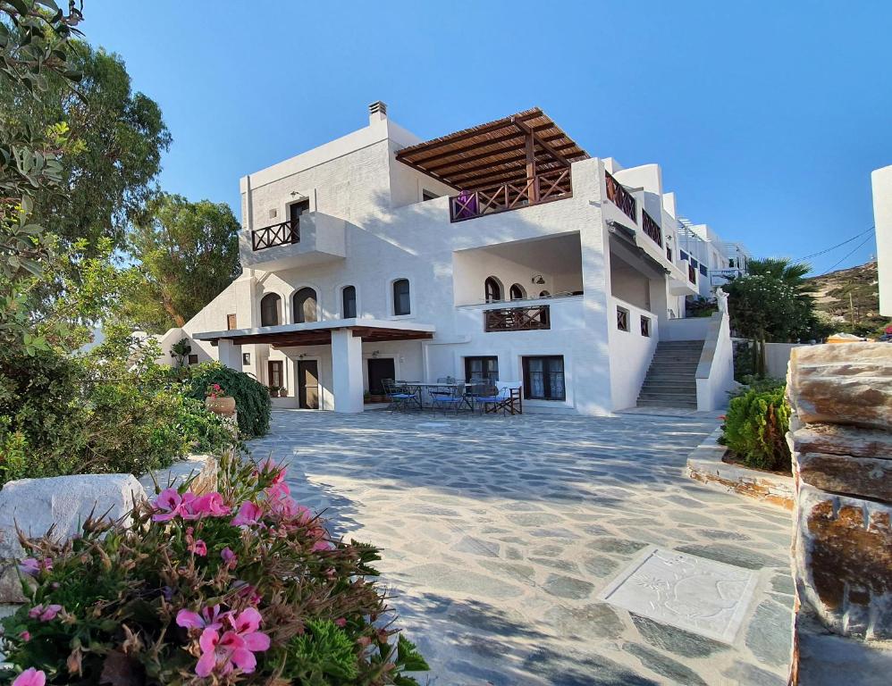 a large white building with flowers in front of it at Dendrinos House in Galissas