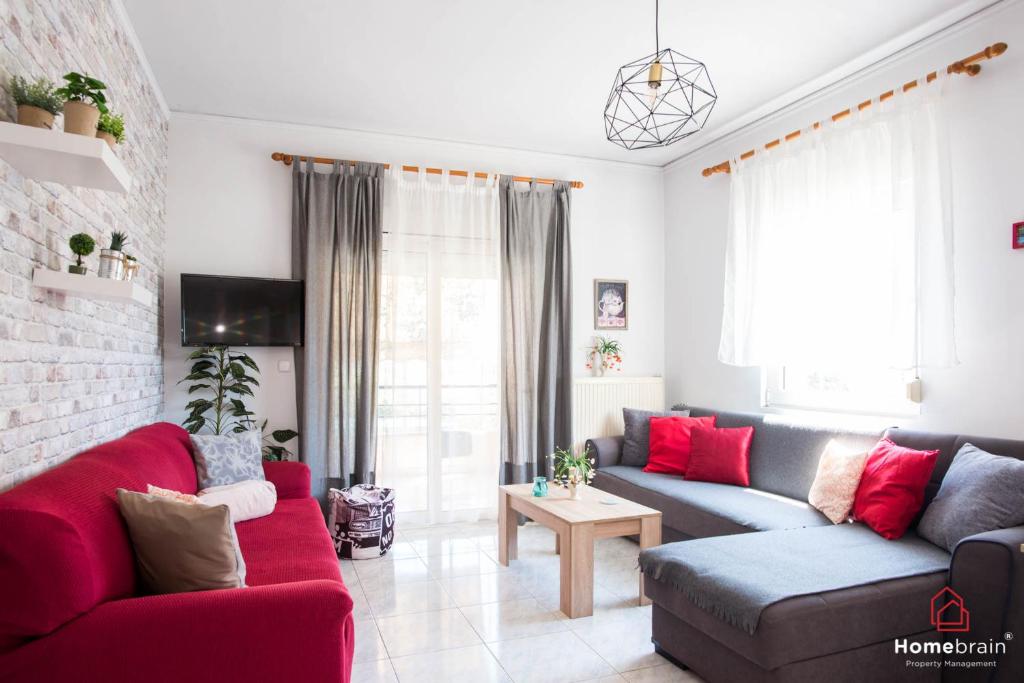 a living room with two couches and a red couch at PK Luxury Apartment, feels like home in Alexandroupoli