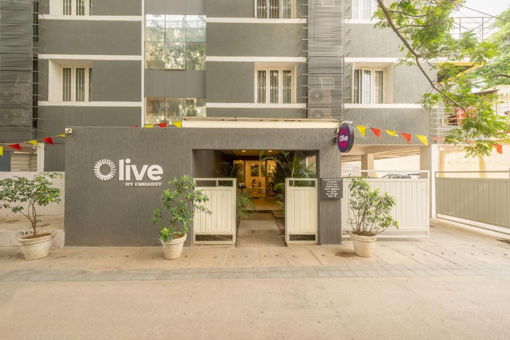 an entrance to a building with plants in front of it at Olive Magrath - By Embassy Group in Bangalore