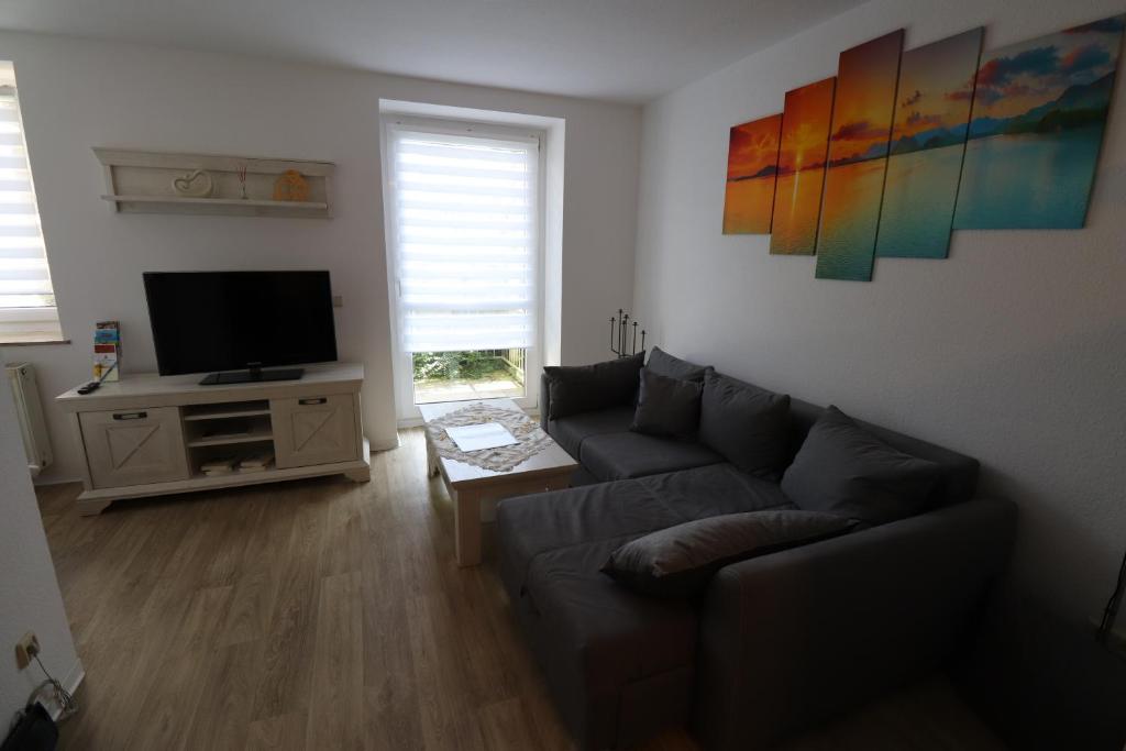 a living room with a couch and a flat screen tv at Gästewohnung "ALTE SPINNEREI" in Kirchberg