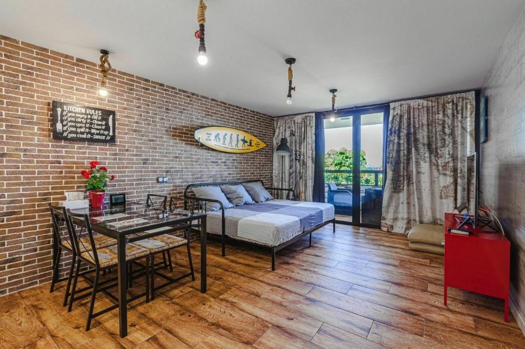 a bedroom with a bed and a table and a brick wall at The Americas Beach in Playa de las Americas