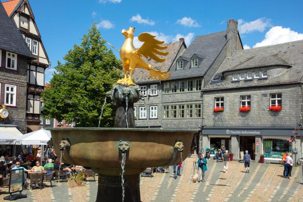 a fountain in the middle of a city with people at Haus Mittenmank am Marktplatz in Goslar