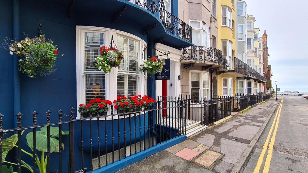 ein blaues Gebäude mit Blumen an den Fenstern einer Straße in der Unterkunft Red Brighton Blue in Brighton & Hove