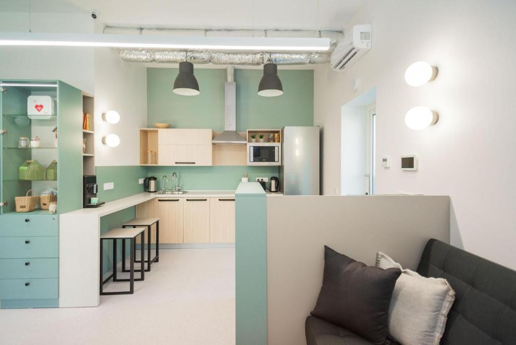 a kitchen with green walls and a couch in a room at CAPSULE HOTEL & HOSTEL in Kharkiv