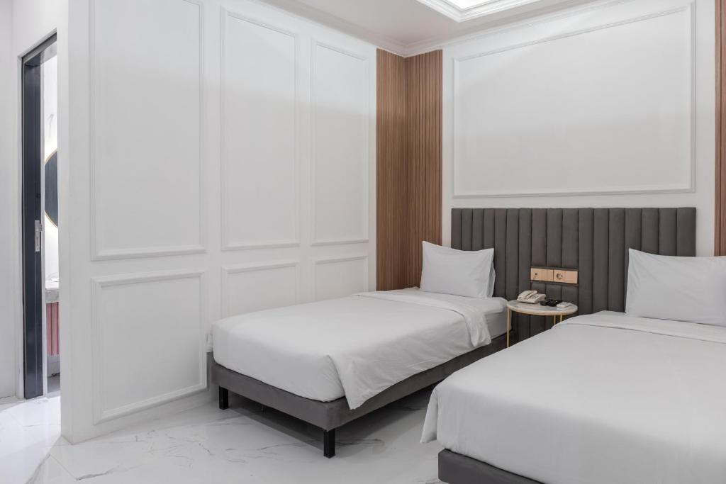 Postel nebo postele na pokoji v ubytování Kala Hotel Semarang