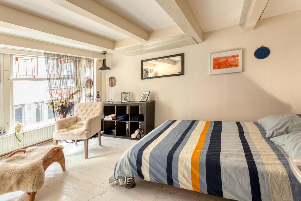 a bedroom with a bed and a chair at B&B 1971 Hazenstraat - Shared Bathroom in Amsterdam