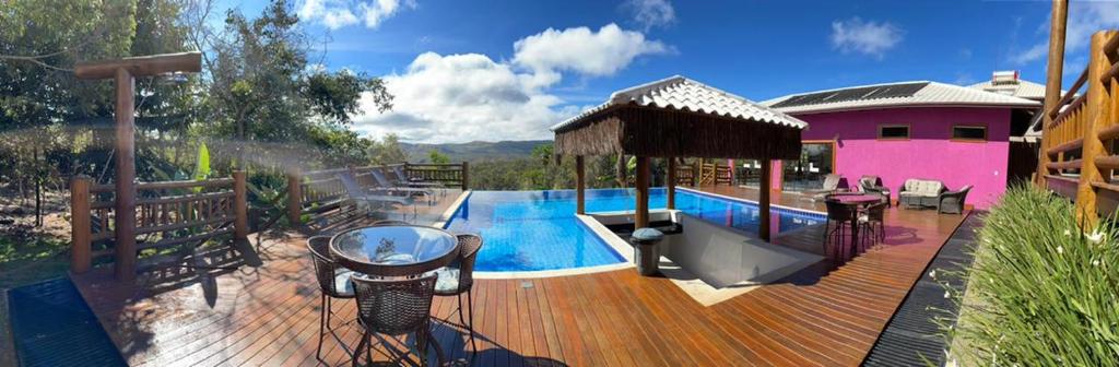 a wooden deck with a swimming pool and a house at Villa Tereza in Alto Paraíso de Goiás